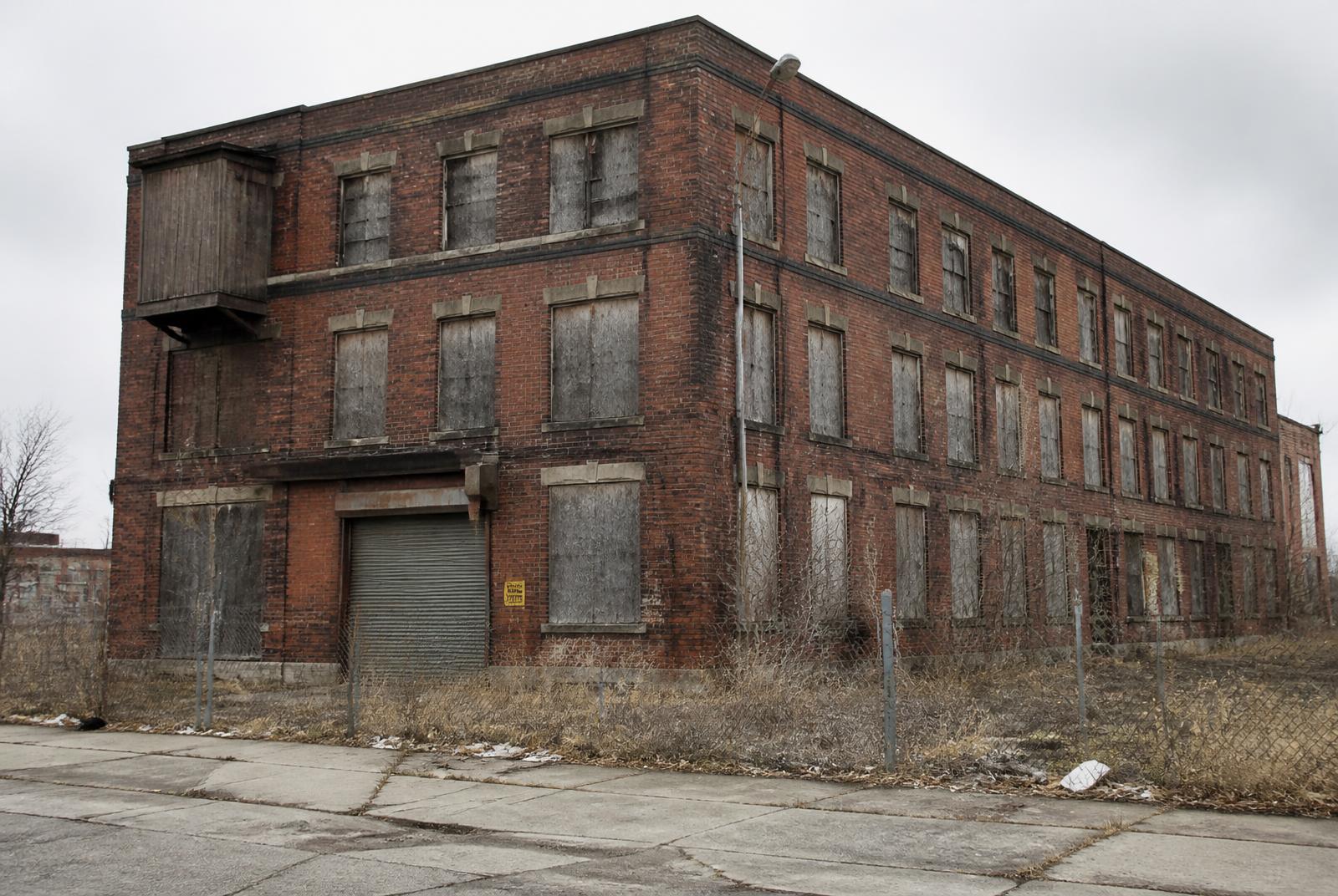 Vacant brick warehouse with boarded windows before renovation